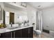Bathroom featuring a double sink vanity with dark wood cabinets, modern fixtures, and tub with shower at 14110 Pastel Ln, Parker, CO 80134