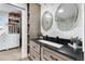 Bathroom featuring dual round mirrors, dark countertops, shaker style cabinets, and walk-in closet at 14110 Pastel Ln, Parker, CO 80134