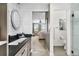 Bathroom with shaker style vanity, round mirror, view to bedroom and separate area with toilet and shower at 14110 Pastel Ln, Parker, CO 80134