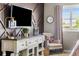 Comfortable bedroom featuring a wall-mounted TV, a vintage-style dresser, a decorative lamp, and a cozy chair near the window at 14110 Pastel Ln, Parker, CO 80134