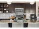 Well-equipped kitchen featuring stainless steel appliances, dark wood cabinetry and a granite countertop island at 14110 Pastel Ln, Parker, CO 80134