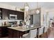 Well-designed kitchen featuring stainless steel appliances, dark cabinets, granite counters, and pendant lighting at 14110 Pastel Ln, Parker, CO 80134