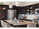 Modern kitchen featuring a large island with granite countertop, stainless steel appliances, and dark wood cabinets at 14110 Pastel Ln, Parker, CO 80134