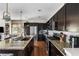 Spacious kitchen with stainless steel appliances, dark wood cabinets, and a large island perfect for entertaining at 14110 Pastel Ln, Parker, CO 80134