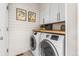 Functional laundry room with modern appliances, overhead cabinets, and a wood countertop for folding laundry at 14110 Pastel Ln, Parker, CO 80134