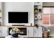 Bright and sunny living room featuring custom shelving, a fireplace, and large windows at 14110 Pastel Ln, Parker, CO 80134