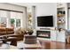 Inviting living room with a cozy fireplace, plush brown leather sofa, and large windows at 14110 Pastel Ln, Parker, CO 80134