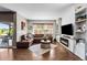 Comfortable living room with a leather sectional sofa, fireplace, custom shelving, and hardwood flooring at 14110 Pastel Ln, Parker, CO 80134