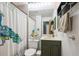 Traditional bathroom with a green vanity, decorative shower curtain, and functional towel rack at 1811 S Quebec Way # 221, Denver, CO 80231