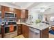 Modern kitchen equipped with stainless steel appliances, granite countertops, and dark wood cabinets at 1811 S Quebec Way # 221, Denver, CO 80231