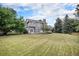 Expansive backyard with a well-maintained lawn, mature trees, and a lovely deck, perfect for relaxation and outdoor entertaining at 5491 S Youngfield W Ct, Littleton, CO 80127