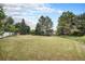 Spacious backyard with an ample lawn area surrounded by mature trees offering a private outdoor oasis at 5491 S Youngfield W Ct, Littleton, CO 80127