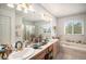 Bright bathroom showcasing double sinks, a soaking tub, and a separate shower at 5491 S Youngfield W Ct, Littleton, CO 80127