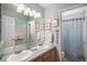 Well-lit bathroom with double sinks, a large mirror, and a separate shower area at 5491 S Youngfield W Ct, Littleton, CO 80127