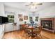 Open dining area with a brick fireplace, windows, and seating at 5491 S Youngfield W Ct, Littleton, CO 80127