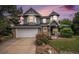 Charming two-story home boasts a unique turret, stone accents, well-manicured lawn, and an attached two-car garage at 5491 S Youngfield W Ct, Littleton, CO 80127