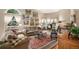 Bright living room featuring neutral walls, hardwood floors, a cozy seating area, and abundant natural light at 5491 S Youngfield W Ct, Littleton, CO 80127