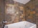 Close-up of bathtub with tile surround and stainless steel fixtures at 1746 S Alcott St, Denver, CO 80219