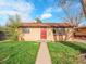 Charming brick home featuring a well-maintained lawn and bright red front door under a partly cloudy sky at 1746 S Alcott St, Denver, CO 80219