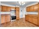 Well-lit kitchen showcasing wood cabinets, stainless steel oven, and tile floors at 1746 S Alcott St, Denver, CO 80219