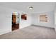 Bright living room featuring neutral carpet, white walls, and an arched opening to the kitchen area at 1746 S Alcott St, Denver, CO 80219