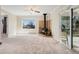 Carpeted living room featuring a wood-burning stove and sliding glass door to the backyard at 640 S Quivas St, Denver, CO 80223
