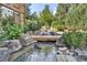 Backyard pond with a waterfall surrounded by plants, trees, and rocks adds to a peaceful outdoor space at 1105 Northwood Ln, Castle Rock, CO 80108