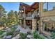 Spacious stone patio underneath a covered deck with a landscaped yard, perfect for outdoor entertaining at 1105 Northwood Ln, Castle Rock, CO 80108