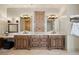 Bathroom with a dual sink vanity, decorative mirrors, and natural wood cabinetry at 1105 Northwood Ln, Castle Rock, CO 80108