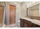 Bathroom with wooden cabinets, granite countertops, decorative mirror, and shower with tiled surround at 1105 Northwood Ln, Castle Rock, CO 80108