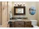Bathroom featuring dark wood vanity with granite countertops and decorative mirror at 1105 Northwood Ln, Castle Rock, CO 80108