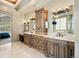 A spacious bathroom with a dual sink vanity, mirrors, and natural wood cabinetry at 1105 Northwood Ln, Castle Rock, CO 80108
