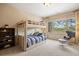 Bright bedroom features a bunk bed, plush carpet, and a scenic outdoor view through a large window at 1105 Northwood Ln, Castle Rock, CO 80108