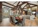 Elegant dining room featuring exposed beams, custom lighting, hardwood floors, and seamless access to the living area at 1105 Northwood Ln, Castle Rock, CO 80108