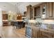 Elegant kitchen with wooden cabinets, granite countertops, a wine cooler, and a large island with seating at 1105 Northwood Ln, Castle Rock, CO 80108