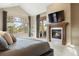 Inviting bedroom with a fireplace, large window, and cozy decor perfect for relaxing and unwinding at 1105 Northwood Ln, Castle Rock, CO 80108