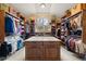 Custom walk-in closet with built-in shelving, center island, and window at 1105 Northwood Ln, Castle Rock, CO 80108