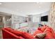 Spacious basement featuring a red sofa, area rug, kitchenette with a stainless steel dishwasher and wall-mounted TV at 2746 Geneva St, Denver, CO 80238