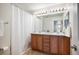 Well-lit bathroom with dual vanity, framed mirror, and combined shower and bathtub with white curtain at 2746 Geneva St, Denver, CO 80238