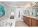 Bright bathroom featuring a soaking tub, double vanity, and stylish décor accents at 2746 Geneva St, Denver, CO 80238