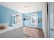 Inviting bedroom with wood floors, light blue walls, bright rug and natural light from the windows at 2746 Geneva St, Denver, CO 80238