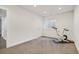 Bright exercise room with carpeted floors, white walls and trim, and a modern stationary bicycle next to a window at 2746 Geneva St, Denver, CO 80238