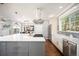 Bright kitchen with gas cooktop on island, stainless appliances, mosaic tile backsplash, and hardwood floors at 2746 Geneva St, Denver, CO 80238