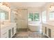 Modern bathroom with marble tile, standalone tub, glass enclosed shower, and double sink vanity at 19249 E Progress Ave, Centennial, CO 80015