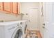 Well-lit laundry room features a washer, dryer, storage cabinets, and tile flooring at 19249 E Progress Ave, Centennial, CO 80015