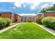 Attractive brick apartment building with well-manicured lawn and inviting entrance walkway under a cloudy blue sky at 2856 Jasmine St, Denver, CO 80207