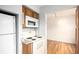 Functional kitchen showcases white appliances, compact design, and an adjacent open space at 2856 Jasmine St, Denver, CO 80207