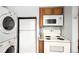 Functional kitchen area with stove, microwave, refrigerator, washer, and dryer, maximizing space at 2856 Jasmine St, Denver, CO 80207
