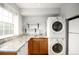 Efficient laundry area featuring stacked washer/dryer, sink, and countertop for added convenience at 2856 Jasmine St, Denver, CO 80207