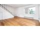 Bright, empty living room with hardwood floors, a staircase, and a large window letting in natural light at 2856 Jasmine St, Denver, CO 80207